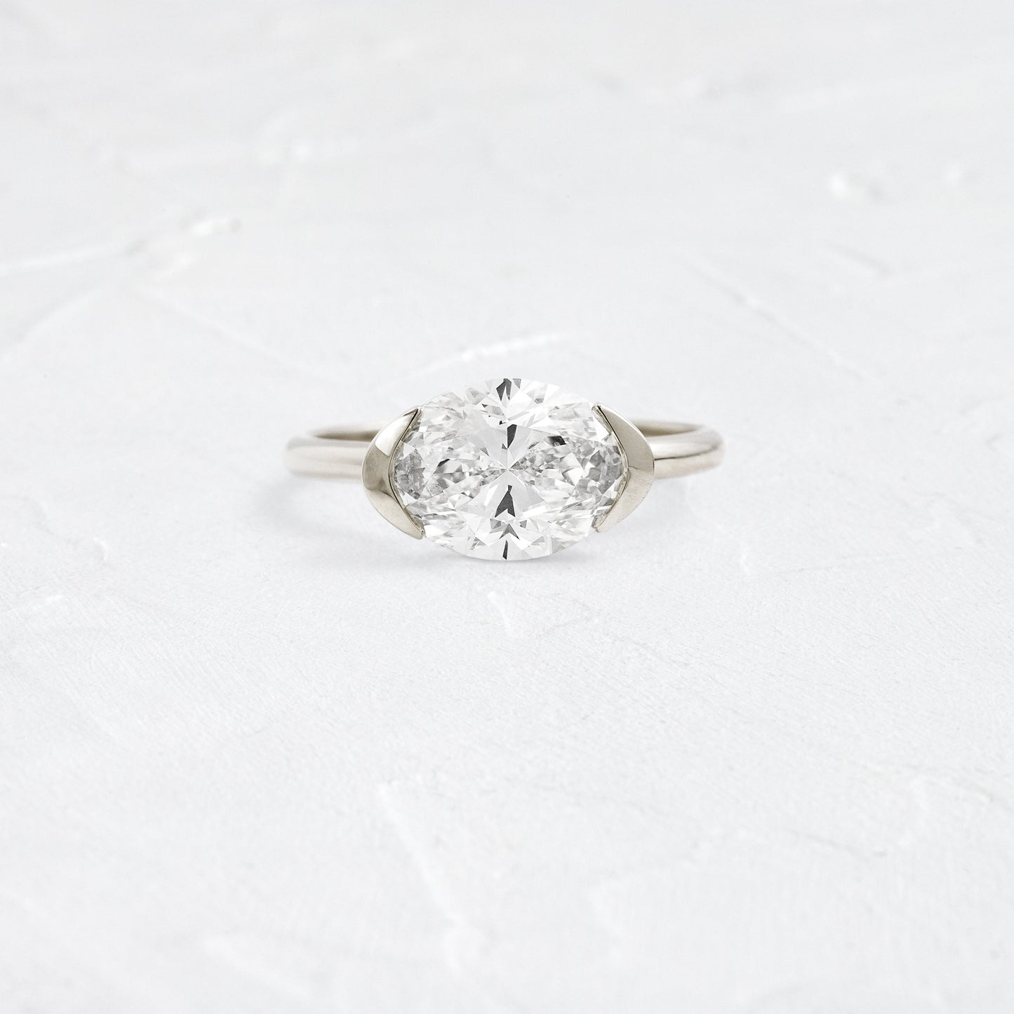 East West Solitaire Half Bezel-Oval Lab Grown Diamond Engagement Ring