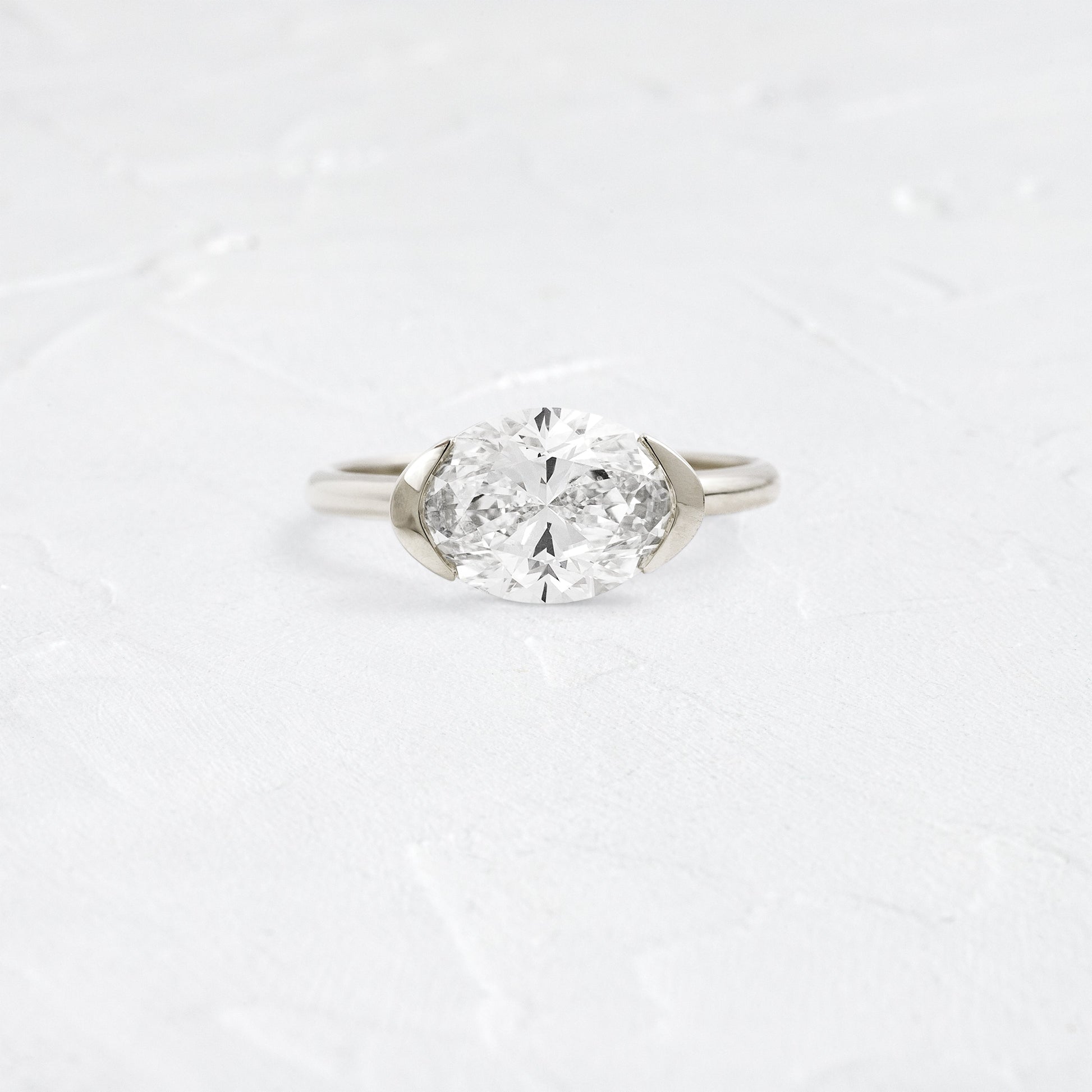 East West Solitaire Half Bezel-Oval Lab Grown Diamond Engagement Ring